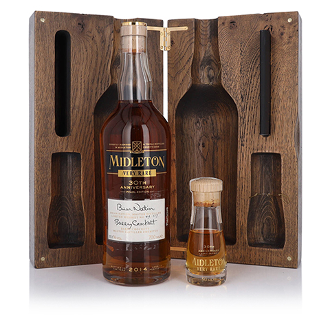 Photograph of a very rare Midleton Whiskey 30th Anniversary Pearl Edition bottle and case. The hinged, wooden case is open behind the standing bottle full of dark brown whiskey. 