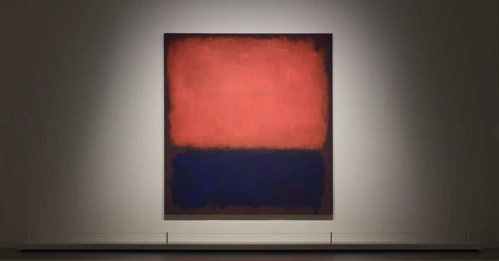 Mark Rothko - Exhibition at Fondation Louis Vuitton in Paris. A horizontal photograph of a square Rothko painting, which is half-light red and half dark blue on the bottom, against a museum wall.